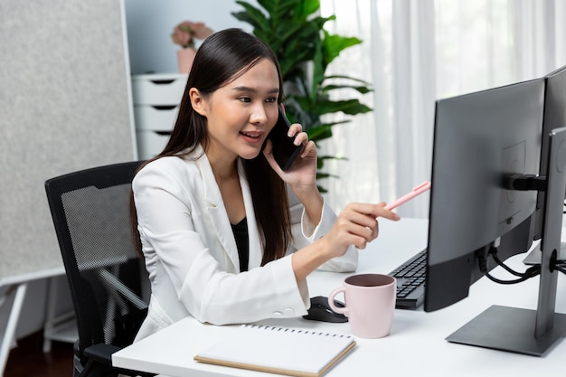 Young Asian businesswoman calling to customer presenting advertise Stratagem