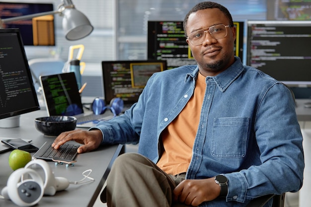 Young IT Technician Posing at Table with Screens