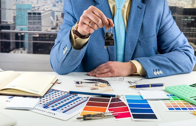 a man in a classic suit designer received the keys to the house he will work on