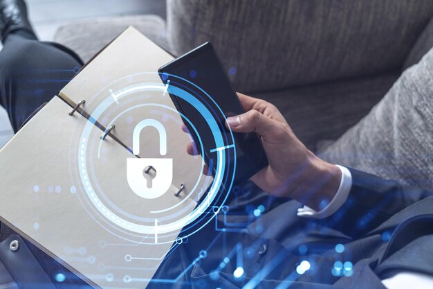 A programmer is browsing the Internet in smart phone to protect a cyber security from hacker attacks and save clients confidential data Padlock Hologram icons over the typing hands Formal wear