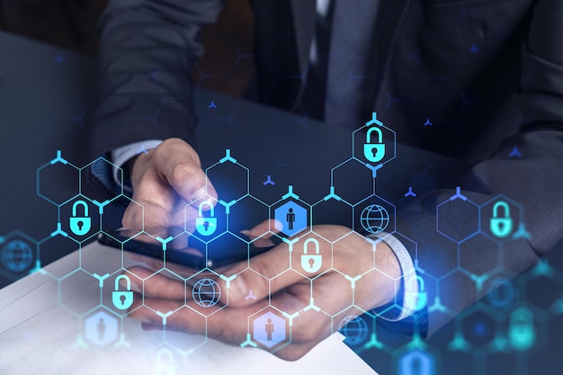 A programmer is browsing the Internet in smart phone to protect a cyber security from hacker attacks and save clients confidential data Padlock Hologram icons over the typing hands Formal wear