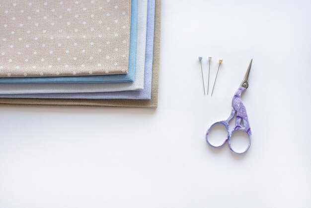 A stack of beautiful fabric for crossstitch and needlework sewing on a white background