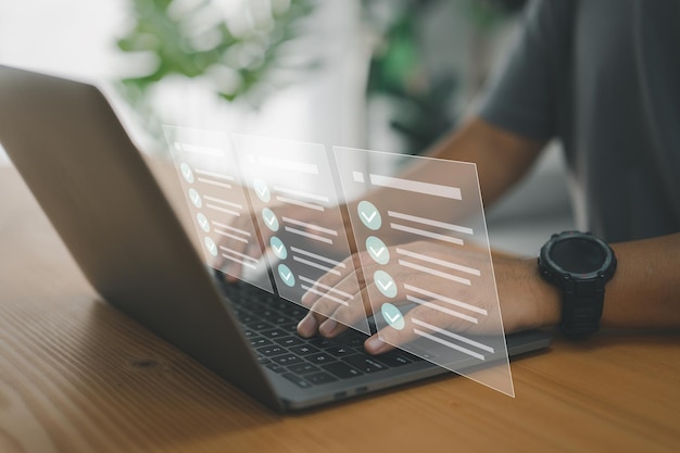 A worker types on a laptop keyboard into a document management system DMS or database which is the concept of using technology to effectively manage files and document storage in digital formatxA