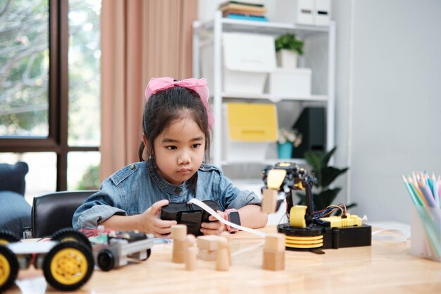 A young girl is playing with a remote control a robot