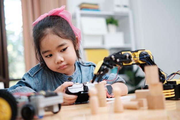 A young girl is playing with a remote control a robot
