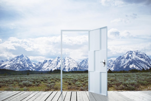 Abstract open door on creative snowy mountains background Travel opportunity and dream concept