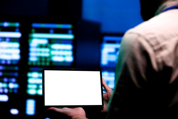 Adept repairman conducting routine auditing of data center server racks using mock up tablet to optimize dataset processing prevent system damages and ensure uninterrupted computing power