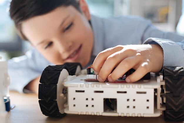 Adorable pre-teen kids inspecting robotic vehicle workshop