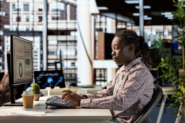 African american female professional works at desk in a corporation