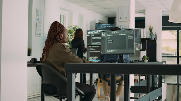 African american programer typing source code on computer to create new user interface. Software engineer writing data in html language to develop security server on terminal window.