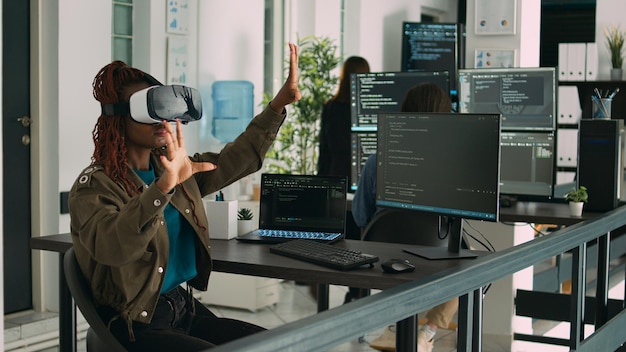 African american programmer working with vr glasses in it development office, using virtual reality headset to develop security program. Big data admin coding html script with database.