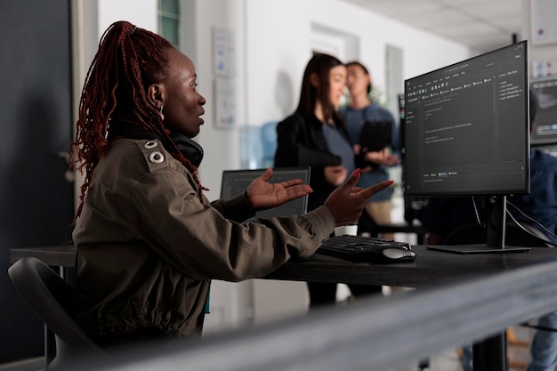 African american system engineer working on html code development and brainstorming ideas to create coding script. Software developer thinking about database server in it big data agency office