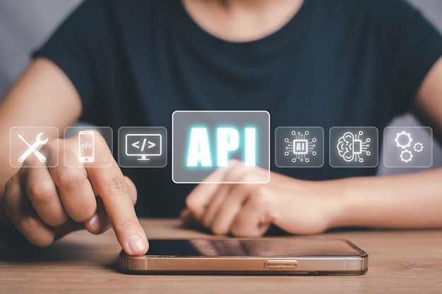 API Application Programming Interface Woman touching on smartphone with VR screen API icon on office desk Software development tool modern technology internet and networking concept