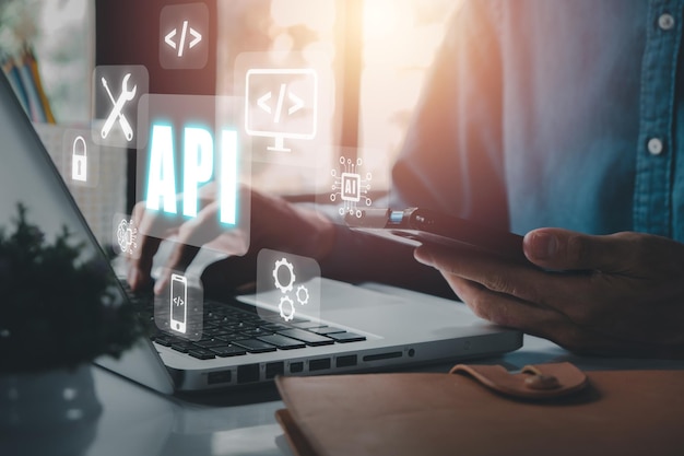 API Application Programming Interface Woman using laptop computer with VR screen API icon on office desk Software development tool modern technology internet and networking concept