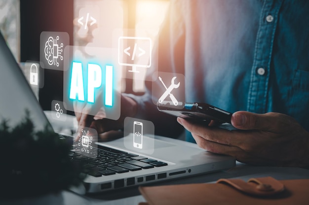 API Application Programming Interface Woman using laptop computer with VR screen API icon on office desk Software development tool modern technology internet and networking concept