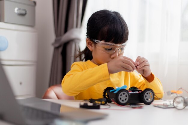 asia students learn at home in coding robot cars and electronic board cables in stem steam mathematics engineering science technology computer code in robotics for kids concept