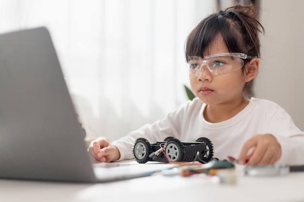 asia students learn at home in coding robot cars and electronic board cables in stem steam mathematics engineering science technology computer code in robotics for kids concept