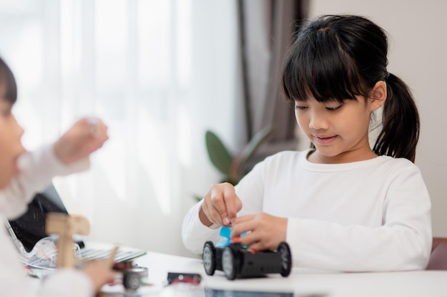 asia students learn at home in coding robot cars and electronic board cables in stem steam mathematics engineering science technology computer code in robotics for kids concept