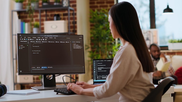 Asian female developer coding cloud computing applications on pc