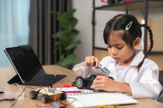 asian littlle girl constructing and coding robot at stem classfixing and repair mechanic toy car