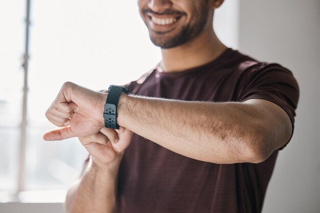 athlete fitness and smart watch with app to check measure or time exercise for tracking health on technology sports man and happy with workout training and cardio wellness in gym facility