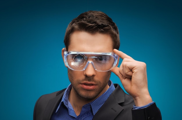 augmented reality, technology, business and people concept -businessman in virtual glasses over blue background