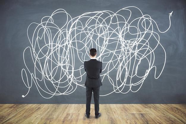 Back view of confused young businessperson with scribble sketch Confusion and think concept