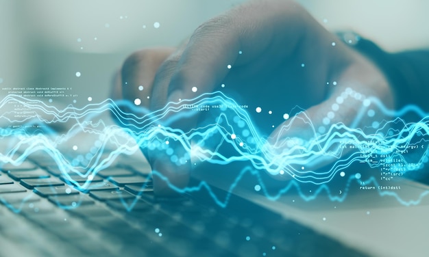 Big data concept with digital waves and abstract programming code on backdrop with man hand typing on laptop