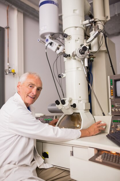 biochemist using large microscope and computer