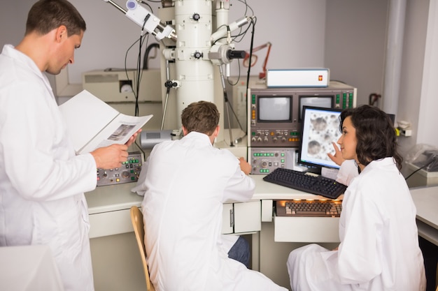 biochemistry students using large microscope and computer
