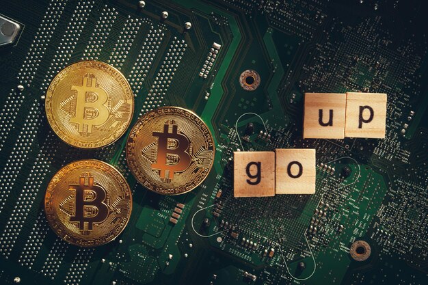 Bitcoins on the background of a computer chip goes up