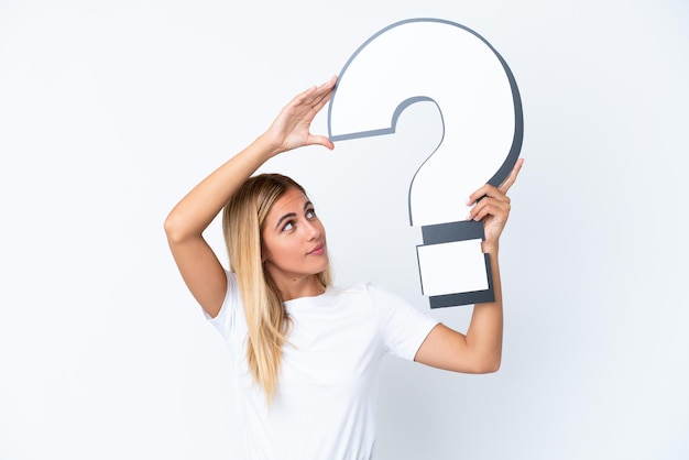 Blonde Uruguayan girl isolated on white background holding a question mark icon