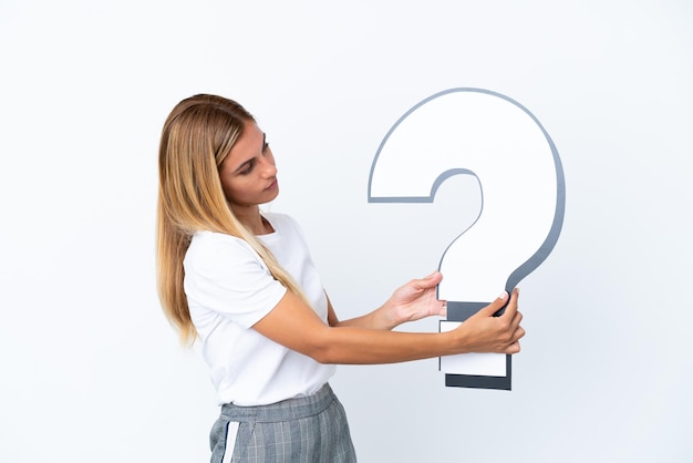 Blonde Uruguayan girl isolated on white background holding a question mark icon