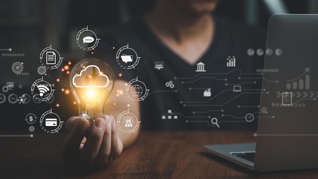 business internet connection technology and digital marketing financial big data bankinghand holding light bulb and laptop computer on desk