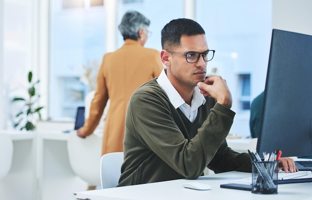 Business man thinking and focus on computer for information technology software development and solution Professional worker reading with glasses for IT decision programming or planning in office