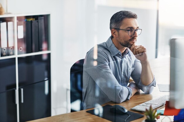 Business man thinking and problem solving on computer for information technology or software update solution Programmer or online developer reading on desktop for decision ideas and reflection