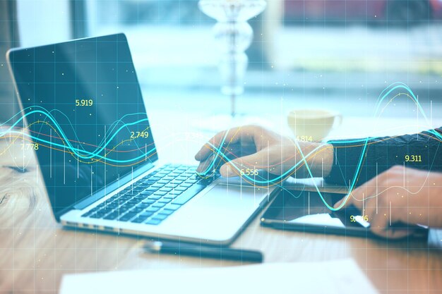 Businessman hands typing on laptop with glowing stock chart