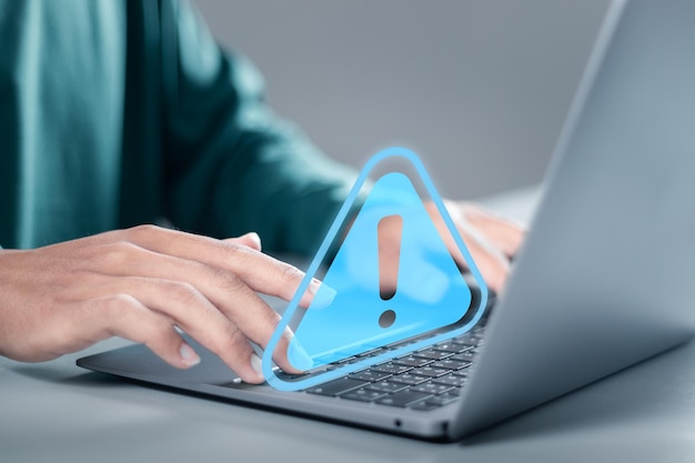 Businessman use laptop with virtual warning sign for caution in investing economic situation warning Business investment risks