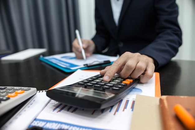 Businessman using calculator financial business calculation.