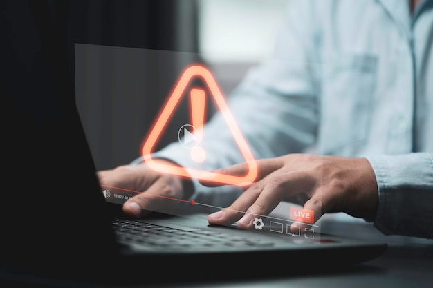 Businessman using computer laptop with red triangle caution warning sign for notification error and maintenance concept