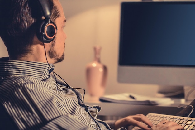 Businessman wearing headphones while using computer