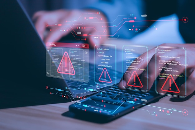 Businessman working on laptop computer at office with exclamation alarm caution warning notification mark sign computer virus detected personal data protection network security concept