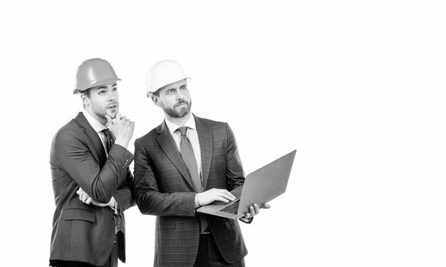Businessmen in helmet with laptop architects planning work chief engineer and executive in hardhat