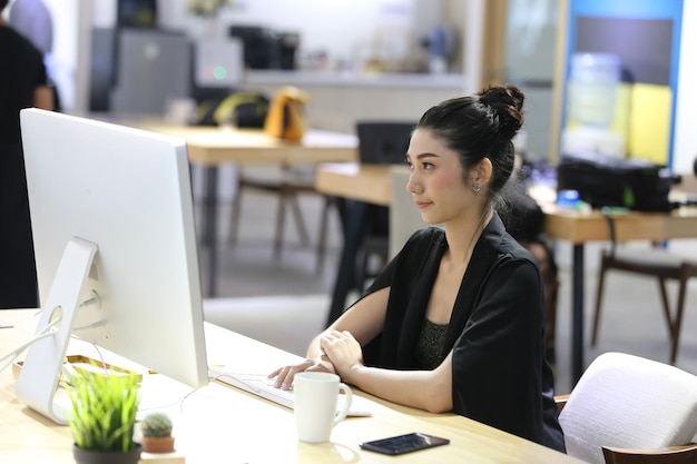 Businesswoman using computer while sitting on desk at office