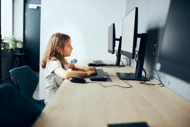 Cant wait to come home bored schoolgirl sitting at desk in computer classroom at school