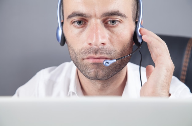 Caucasian customer support operator with headset in office.