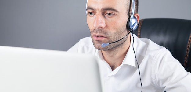 Caucasian customer support operator with headset in office.