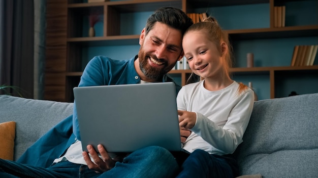 cheerful father and little daughter watching cartoons on internet spending time together at home