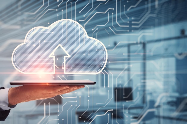 Close up of businessman hand holding tablet or smartphone with glowing cloud hologram on blurry office interior background Server and data storage concept Double exposure