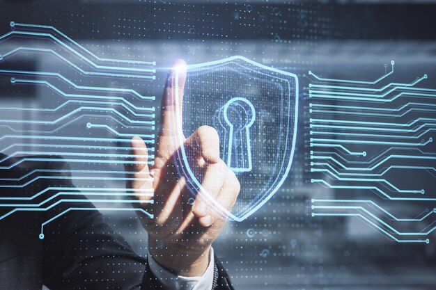 close up of businessman hand pointing at abstract glowing secure web safety and protection hologram on blurry office interior background double exposure